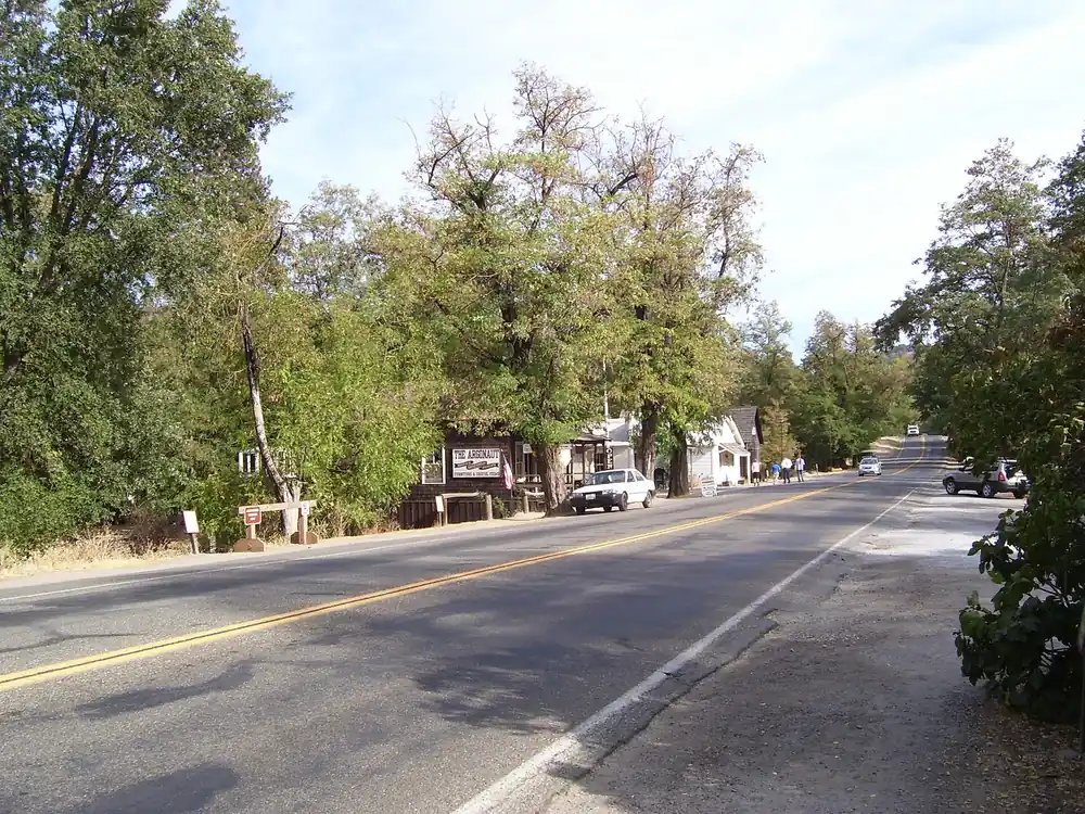 Historic wooden storefronts under mature trees along Coloma Road in Coloma California